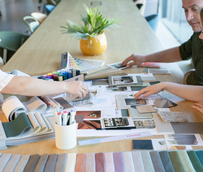 Studio ontwerper aan het werk met materialen, kleurstalen en moodboards in de ontwerpstudio van Thereca